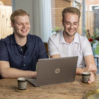 Twee jongen kijken op laptop